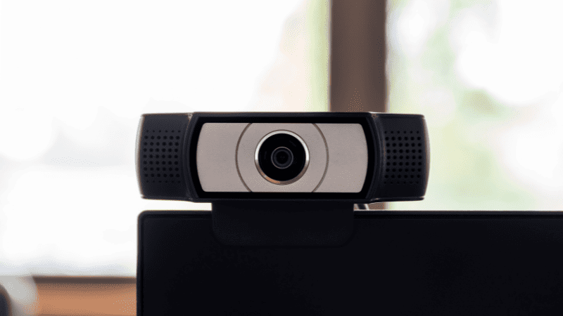 Webcam externa instalada sobre monitor de computador para videochamadas no home office.